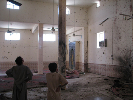 Two Iraqi men inspect a suicide bomb scene in Duloiyah, Salahuddin, Iraq, April 23, 2009. A suicide bomber, around 20 years old, blew himself up in a local mosque, claiming the lives of four prayers and wounding ten others. (Xinhua/Shaalan Jubury)