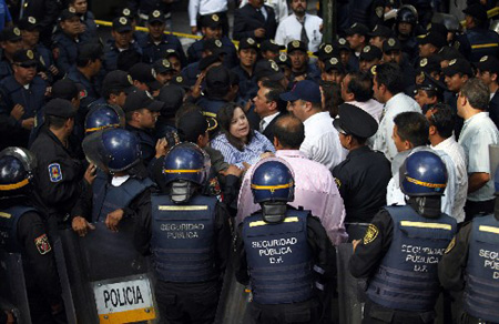 Mexican policemen gather in front of a building where an auditorium inside collapsed in Mexico City April 23, 2009.