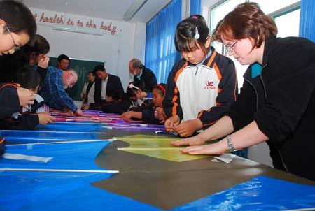 Canadian kite lovers teach pupils to make Canadian-style kites at Xingfujie Primary School in Weifang, east China's Shandong Province, April 23, 2009. Canadian participants of the 26th International Kite Festival were invited to the school for cultural exchanges with pupils Thursday. [Wang Lijun/Xinhua] 