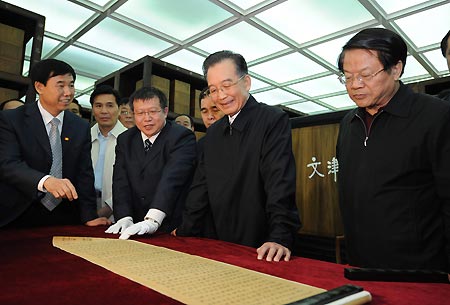 Chinese Premier Wen Jiabao (2nd R) views a treasure collected by the National Library in Beijing, capital of China, April 23, 2009. Premier Wen visited the National Library and the Commercial Press on April 23, the World Book and Copyright Day. 