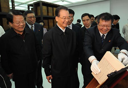 Chinese Premier Wen Jiabao (C Front) views a treasure collected by the National Library in Beijing, capital of China, April 23, 2009. Premier Wen visited the National Library and the Commercial Press on April 23, the World Book and Copyright Day. 