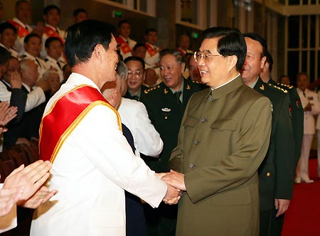Chinese President Hu Jintao (R Front) shakes hands with fighting hero Mai Xiande during his meeting with representatives of veterans, heroes and models of the Navy of the Chinese People's Liberation Army (PLA) in Beijing, capital of China, April 24, 2009, on the occasion of the 60th anniversary of the founding of the PLA Navy. [Xinhua]