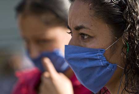  A woman wears a mask to prevent from being infected by the swine flu virus in the Mexico City, capital of Mexico, April 25, 2009. The World Health Organization (WHO) on Saturday declared the swine flu outbreak in Mexico and the United States a 