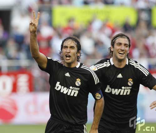 Real Madrid's Raul Gonzalez from Spain (L) reacts after scoring with teammates during their La Liga soccer match against Sevilla at the Ramon Sanchez Pizjuan stadium in Sevilla, Sunday, April 26, 2009.