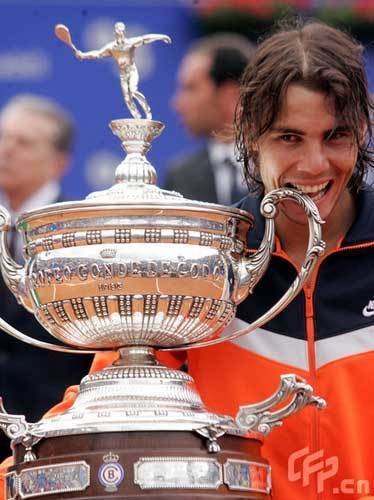 Rafael Nadal of Spain bites the trophy after defeating compatriot David Ferrer in the final of the Barcelona Open tennis tournament April 26, 2009.