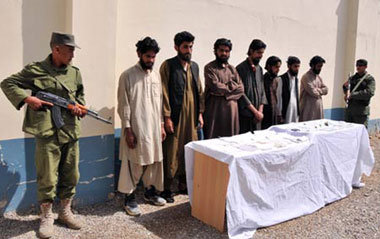 Seven arrested Taliban members stand in front of a wall in Helmand province, southern Afghanistan, April 25, 2009.