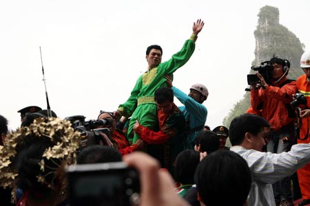 Dawaz performer Samit Ijon (Top) celebrates after finishing walking on the over 700-meter-long and 300-meter-high wire with a gradient as steep as over 39 degrees in the Tianmen Mountain in Zhangjiajie, central-south China's Hunan Province, April 25, 2009. 