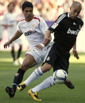 Real Madrid's Fabio Cannavaro (R) controls the ball next to Sevilla's Renato during their Spanish First Division soccer match at Seville's Sanchez Pizjuan stadium April 26, 2009.