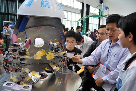 Visitors view a space robot during the Juvenile Robot Contest of Fujian Province in Putian City, southeast China's Fujian Province, April 26, 2009. More than 400 juvenile contestants took part in the competitions of five categories. (Xinhua/Lin Jianbing)