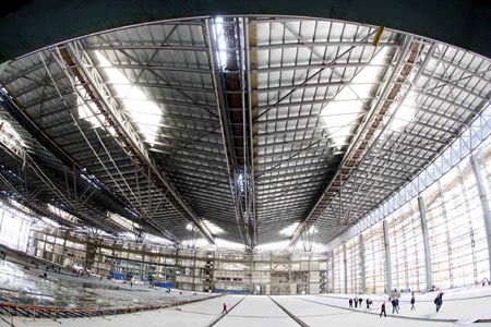 Construction workers get along with the interior decoration inside the west exhibition hall of the Theme Pavilion for the Shanghai 2010 World Expo, in Shanghai, east China, April 26, 2009.