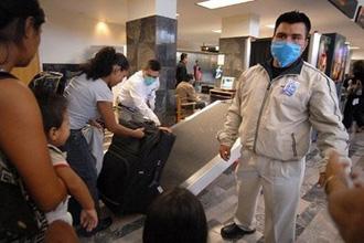 Airport employees wear masks as a preventive measure against a possible swine flu infection in Tijuana, Mexico. [David Maung/CCTV/AFP] 