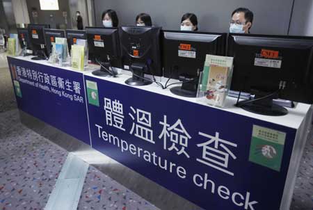  Staff members check the temperature of passengers with the help of machines at Hong Kong International Airport in Hong Kong, south China, April 27, 2009. Hong Kong Special Administrative Region has taken measures to contain the possible spread of swine flu.