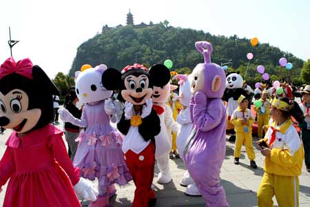 Different cartoon stars play with children in a scenic spot of Nantong Horticulture Expo Park in Nantong, a city of east China's Jiangsu Province, April 27, 2009. [Photo:Xinhua]