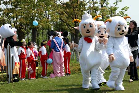 Cartoon stars Happy Sheep play with children in a scenic spot of Nantong Horticulture Expo Park in Nantong, a city of east China's Jiangsu Province, April 27, 2009. [Photo:Xinhua]