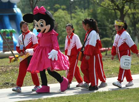 Cartoon star Mickey Mouse plays with children in a scenic spot of Nantong Horticulture Expo Park in Nantong, a city of east China's Jiangsu Province, April 27, 2009. [Photo:Xinhua]