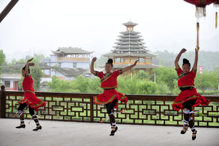 Amateur performers of China's Dong ethnic group dance for tourists in Enshi, central China's Hubei Province, April 26, 2009. A performing group founded by 53 local villagers in 2006 has become popular to tourists from at home and abroad.