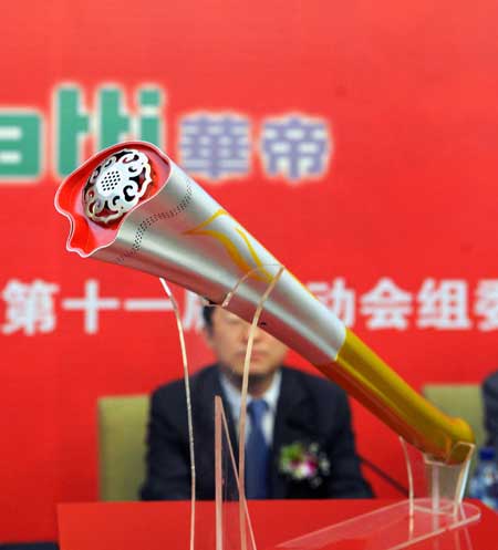 Photo taken on April 28, 2009 shows the torch named 'Ruyi' for China's 11th National Games in Jinan, capital of east China's Shandong Province. Using the image of Chinese traditional ruyi, an s-shaped ornamental object which is usually made of jade and is a symbol of good luck, the torch made a debut in Jinan on Tuesday. [Xinhua]