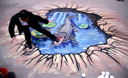 A man poses for a photo on a cubic drawing displayed at the Xuanwuhu Park in Nanjing, capital of east China's Jiangsu Province, April 25, 2009. More than 30 such pictures are displayed here recently, a strong cubic effect of which can be seen from a certain angle. [Xinhua/Wang Xin]