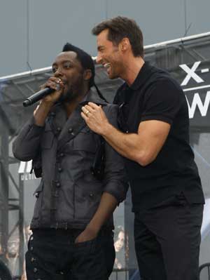 Actors Hugh Jackman (R) and Will.i.am stand on stage at the premiere of the movie 