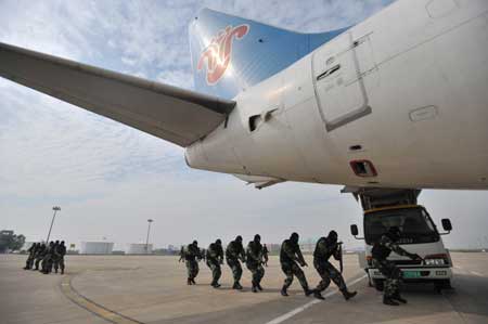 Soldiers sneak up onto the "hijacked" plane in the anti-hijacking exercise held at Tianhe Airport in Wuhan, capital of central China