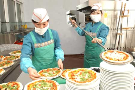 Chefs arrange pizza at the first Italian restaurant in Pyongyang, capital of the Democratic People's Republic of Korea (DPRK), in this picture released by Korean Central News Agency (KCNA) on April 28, 2009. 