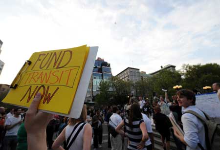 A local resident holds a banner to attend a protest against the raise of public transportation fares at Union Square in New York, the United States, April 28, 2009. 