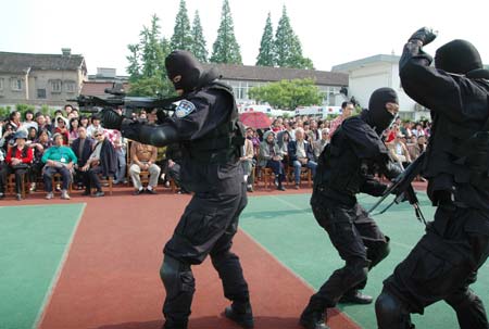 Chinese riot policemen present a demonstration of anti-riot skills for local residents at an open day in Suzhou, east China's Jiangsu Province April 28, 2009. Local police displayed police vehicles, weapons, shields, dogs and presented various skills to the citizens that day.