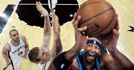 Dallas Mavericks' Erick Dampier (right) shoots over San Antonio Spurs defender Matt Bonner (center) as Spurs guard Tony Parker (9), of France, looks on during the second quarter of Game 5 of a first-round Western Conference NBA playoff basketball game in San Antonio on Tuesday. [AP]