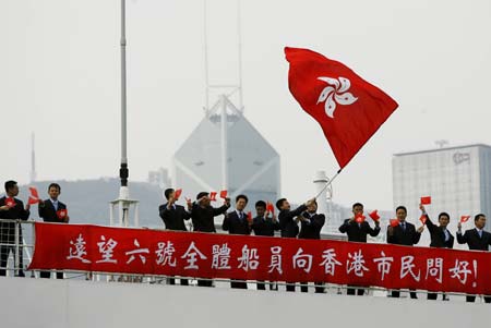 Crew members wave the flag of Hong Kong Special Administrative Region as China
