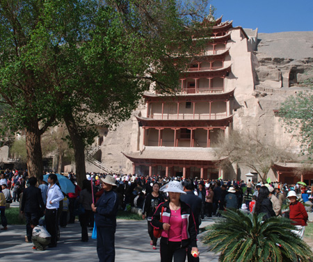 Chinese tourists visit the Mogao Grottoes, a world cultural heritage, near Dunhuang in northwest China's Gansu Province, May 2, 2009, the second day of the three-day May Day holiday. China has a totality of 37 world heritages which attract many tourists in the holiday. 
