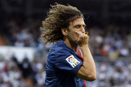 Barcelona's captain Carles Puyol kisses his captain band as he celebrates his goal against Real Madrid during their Spanish first division soccer match at Santiago Bernabeu stadium in Madrid May 2, 2009. (Xinhua/Reuters Photo)