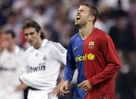 Barcelona&apos;s Gerard Pique (R) celebrates his goal as Real Madrid&apos;s Gonzalo Higuain watches during their Spanish First Division soccer match at Santiago Bernabeu stadium in Madrid May 2, 2009. (Xinhua/Reuters Photo)