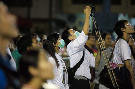 Spectators with facemasks watch contestants participating in the Bun Scrambling-up Competition during the Tai Ping Qing Jiao Festival on Cheung Chau island in Hong Kong, South China, May 2, 2009.(Xinhua/Zhou Lei)