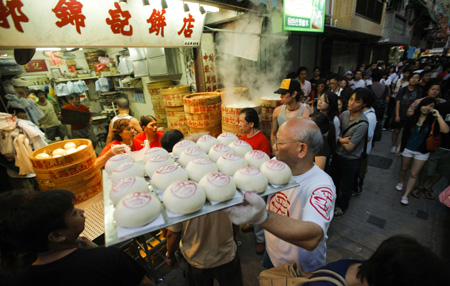 A vendor of a bun shop delivers buns during the Tai Ping Qing Jiao Festival on Cheung Chau island in Hong Kong, South China, May 2, 2009.(Xinhua/Zhou Lei)