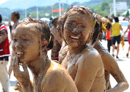 Two girls of the Va ethnic group are seen covered with clay during a carnival at the Va Ethnic Autonomous Prefecture of Cangyuan, southwest China's Yunnan Province, May 2, 2009. [Chen Haining/Xinhua] 