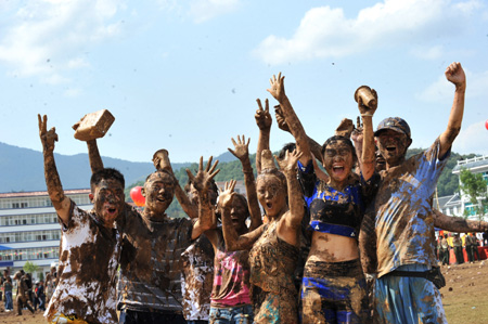 People are seen covered with clay during a carnival at the Va Ethnic Autonomous Prefecture of Cangyuan, southwest China's Yunnan Province, May 2, 2009. [Chen Haining/Xinhua] 