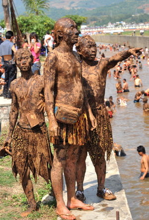 People are seen covered with clay during a carnival at the Va Ethnic Autonomous Prefecture of Cangyuan, southwest China's Yunnan Province, May 2, 2009. [Chen Haining/Xinhua]