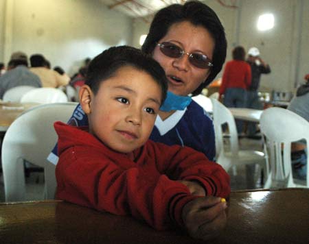 Four-year-old Edgar Hernandez (L) who has recovered from the A/H1N1 flu influenza recently, and his mother rest in a free dining room at his hometown in Veracruz state in Mexico May 2, 2009. Hernandez is the first patient who was infected by the A/H1N1 flu influenza in Mexico. [Xinhua]