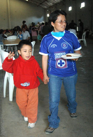 Four-year-old Edgar Hernandez (L), who has recovered from the A/H1N1 flu influenza recently, walks outside a free dining room with his mother at his hometown in Veracruz state in Mexico May 2, 2009. Hernandez is the first patient who was infected by the A/H1N1 flu influenza in Mexico. [Xinhua]
