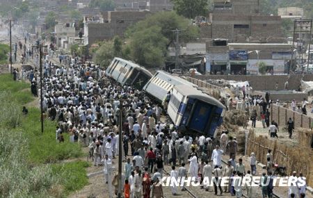 Men assist an injured passenger after a train derailed in Hyderabad May 3, 2009. About 25 injured were reported after the train, heading from Lahore to Karachi, derailed in southern Pakistan 's Sindh province , witnesses said.[Xinhua/Reuters]