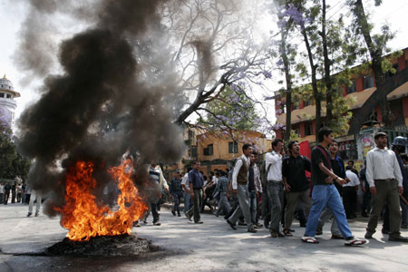 Demonstrators chant slogans near the burning tyres during a protest against Nepali army chief's being sacked, in Kathmandu, capital of Nepal, May 3, 2009. The Nepali government has sacked Chief of the Army Staff (CoAS) Rookmangud Katawal, Nepali government spokesman Krishna Bahadur Mahara said on Sunday. [Xinhua]