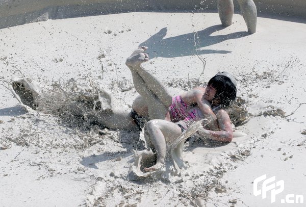 Two females are entangled in dogfight during a distinctive Women's Mud Wrestling Match, as some 40 female contestants from both China and overseas take part in this very amusing sport with the skin-friendly slurry and mud from the deep sea, in Wuhan, central China's Hubei Province, May 3, 2009.[Xiong Bo/CFP]