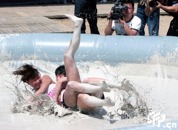 Two females are entangled in dogfight during a distinctive Women's Mud Wrestling Match, as some 40 female contestants from both China and overseas take part in this very amusing sport with the skin-friendly slurry and mud from the deep sea, in Wuhan, central China's Hubei Province, May 3, 2009.[Xiong Bo/CFP]