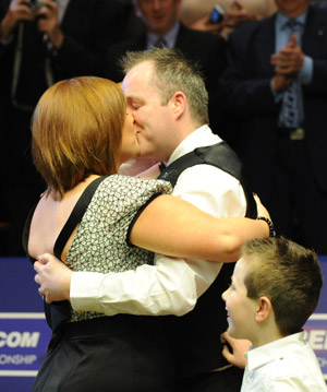 Scotland's John Higgins kisses his wife in the awarding ceremony after defeats England's Shaun Murphy by 18-9 in the two-day final match of 2009 World Snooker Championship in Sheffield, England, May 4, 2009. [Xinhua]