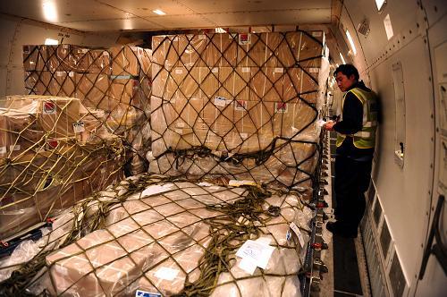 The second batch of Chinese humanitarian materials to tackle influenza A/H1N1,including face masks, eye masks, gloves, disinfecting devices and clinical thermometers, is loaded onto a chartered China Southern Airlines aircraft at the Beijing Capital International Airport on Monday, May 4 2009. [Photo: xinhua.com] 