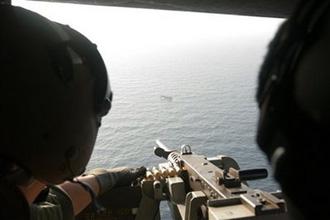 In this photo taken on Monday, May 4, 2009 and released by South Korea's Joint Chiefs of Staff, South Korean snipers on a helicopter aim at a pirate ship about 37 kilometers (23 miles) south of Aden port in Yemen. [HO/CCTV/AP Photo] 