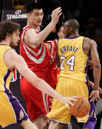 Los Angeles Lakers guard Kobe Bryant passes the ball behind his back to team mate Pau Gasol as Houston Rockets center Yao Ming defends during the first half of Game 1 of their NBA Western Conference semi-final basketball playoff game in Los Angeles, May 4, 2009. [Agencies/China Daily]