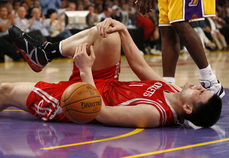 Houston Rockets center Yao Ming lays on the court after injuring his right knee in the 4th quarter against the Los Angeles Lakers during Game 1 of their NBA Western Conference semi-final basketball playoff game in Los Angeles, May 4, 2009. [Agencies/China Daily]