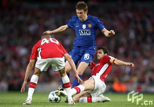Manchester United's Michael Carrick gets tackled by Arsenal's Francesc Fabregas 