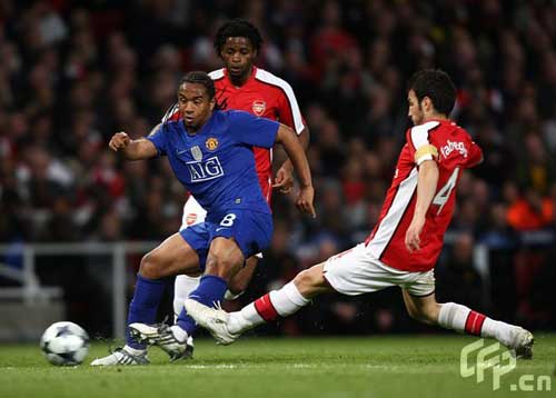 Manchester United's Oliveira Anderson (L) and Arsenal's Francesc Fabregas battle for the ball.